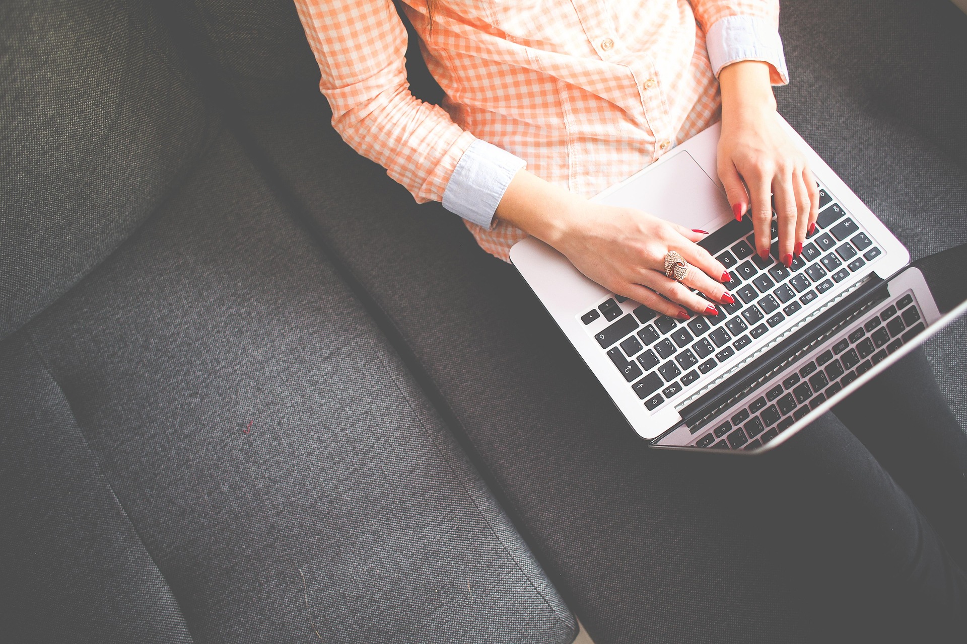 Frau auf Sofa mit Laptop